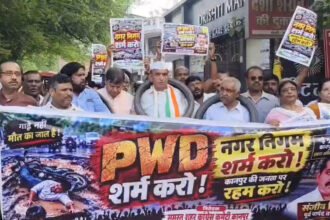 कानपुर: टूटी सड़कों पर कांग्रेस का अनोखा विरोध, गले में टायर डालकर निकाली पदयात्रा, गड्ढों पर चढ़ाए फूल